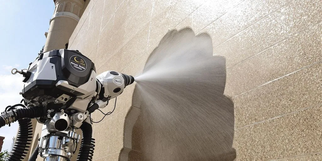 آلة تنظيف بالبخار حديثة تنظف واجهة مبنى تراثي في مكة